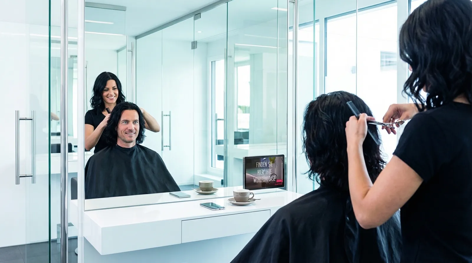 Mann, 40 im Coiffeursalon, auf dem Screen der Spot von Bauarena