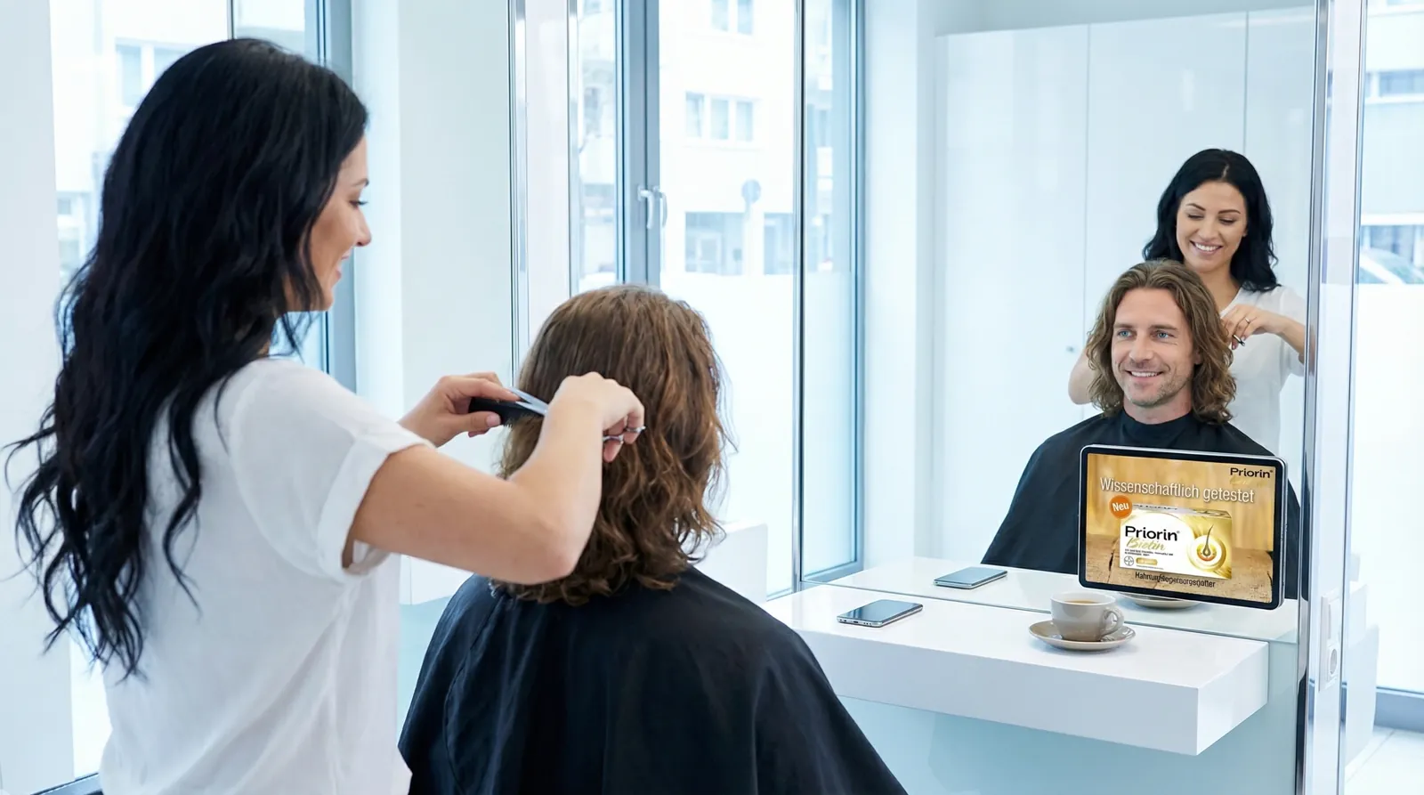 Mann, 40 im Coiffeursalon, auf dem Screen der Spot von Bayer