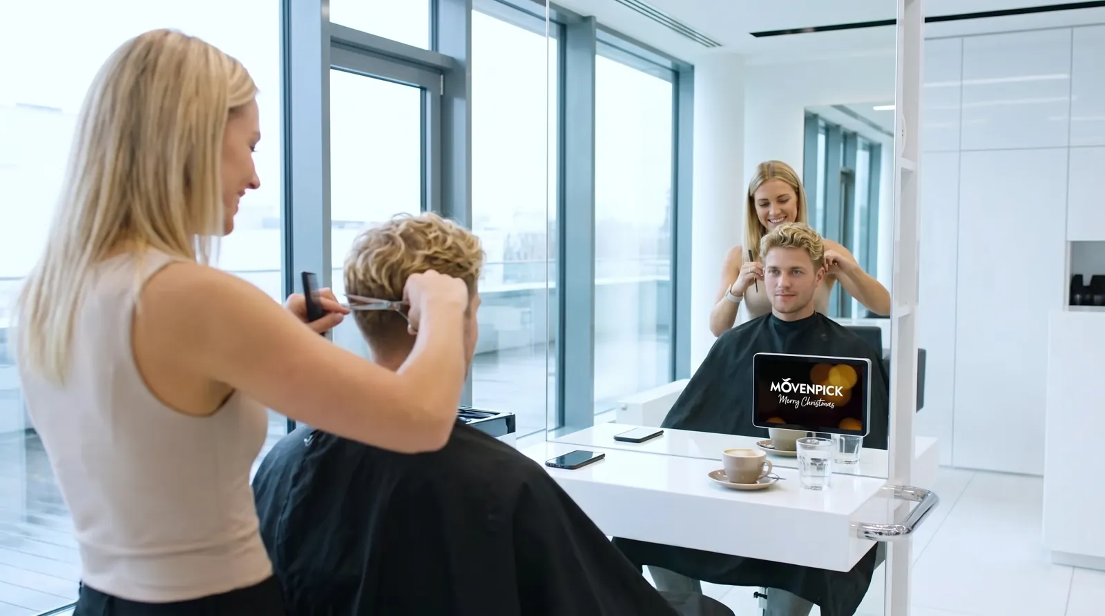 Mann, 20 im Coiffeursalon, auf dem Screen der Spot von Froneri / Mövenpick