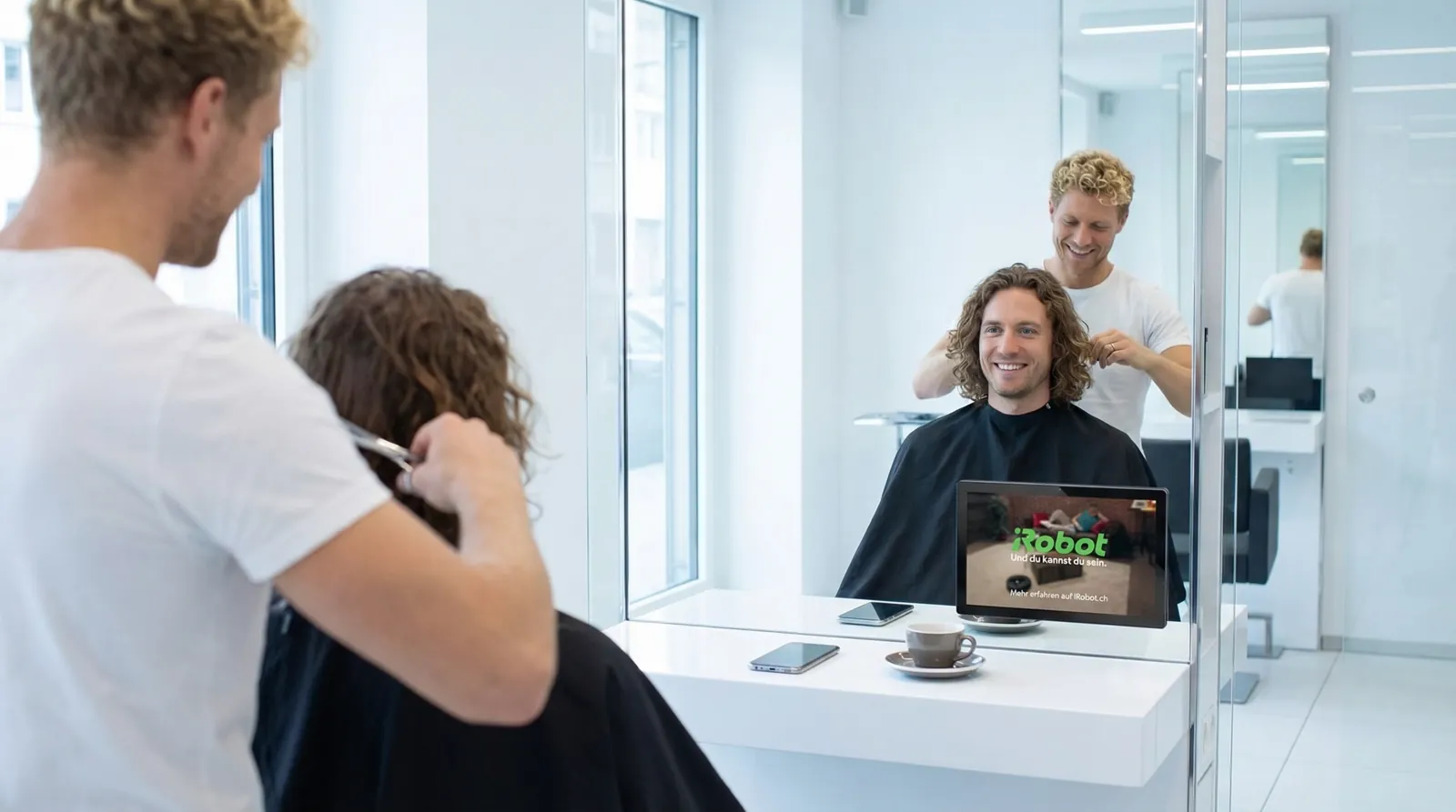 Mann, 30 im Coiffeursalon, auf dem Screen der Spot von iRobot