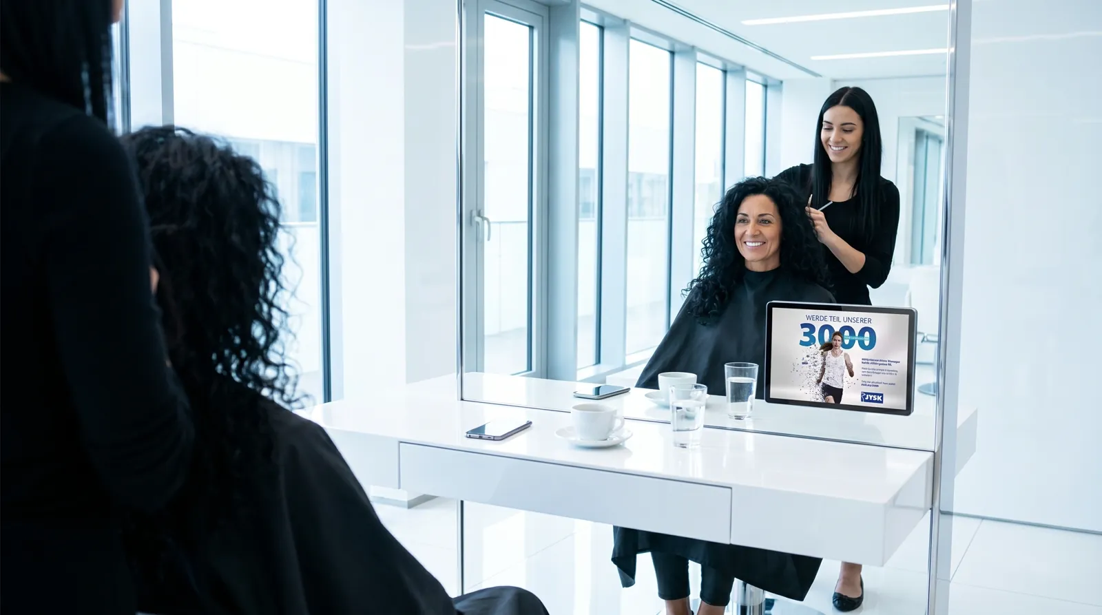 Frau, 40 im Coiffeursalon, auf dem Screen die Werbung von JYSK