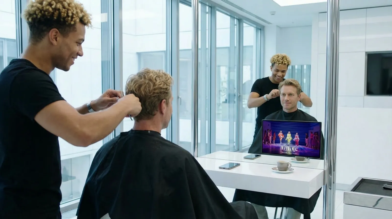 Mann, 40 im Coiffeursalon, auf dem Screen der Spot von Rent a Show (Mamma Mia)