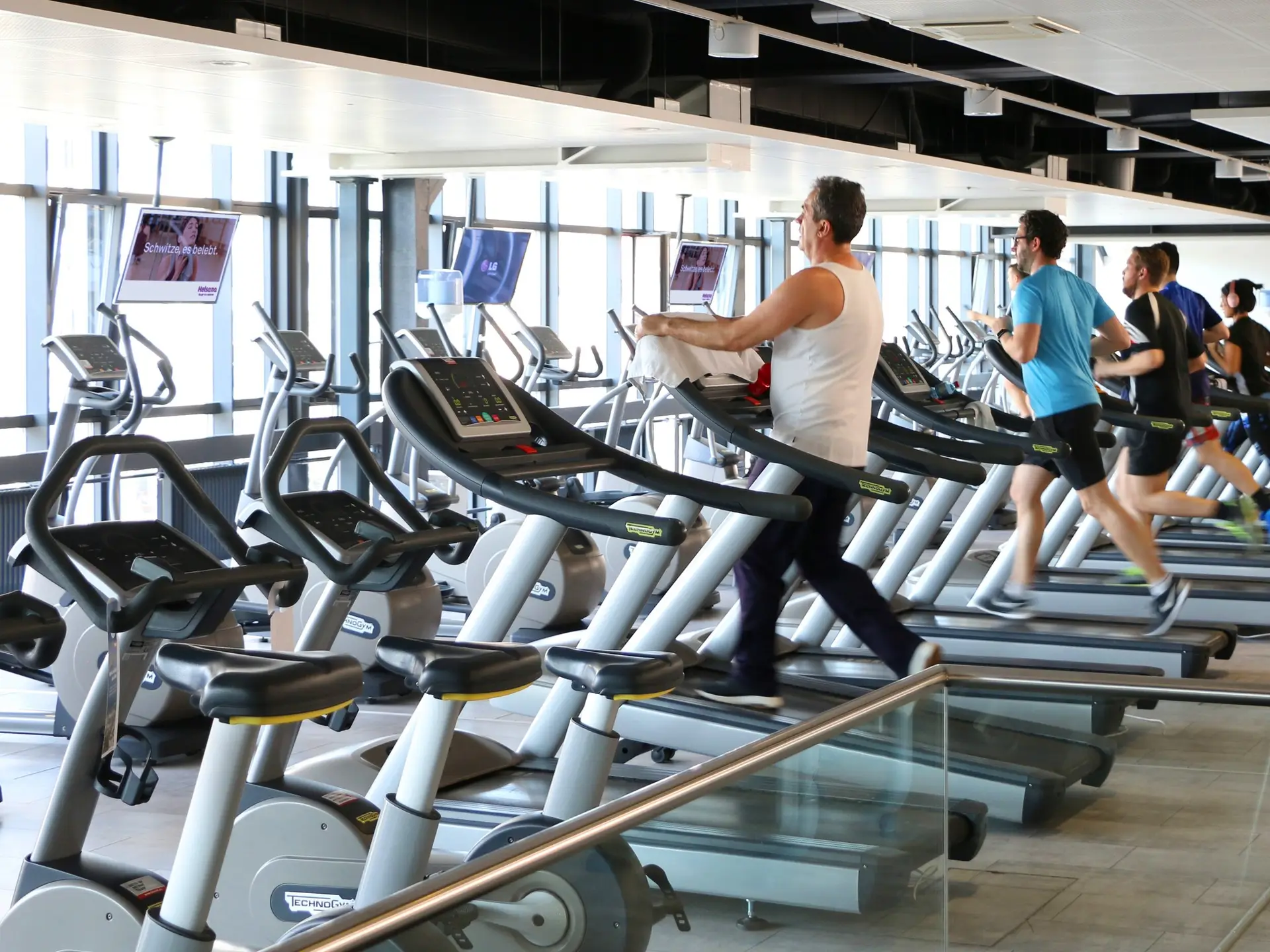 Fitnessstudio mit smadooh-Screens über den Laufbändern